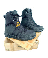 Black tactical boots on a wooden crate with a blue background