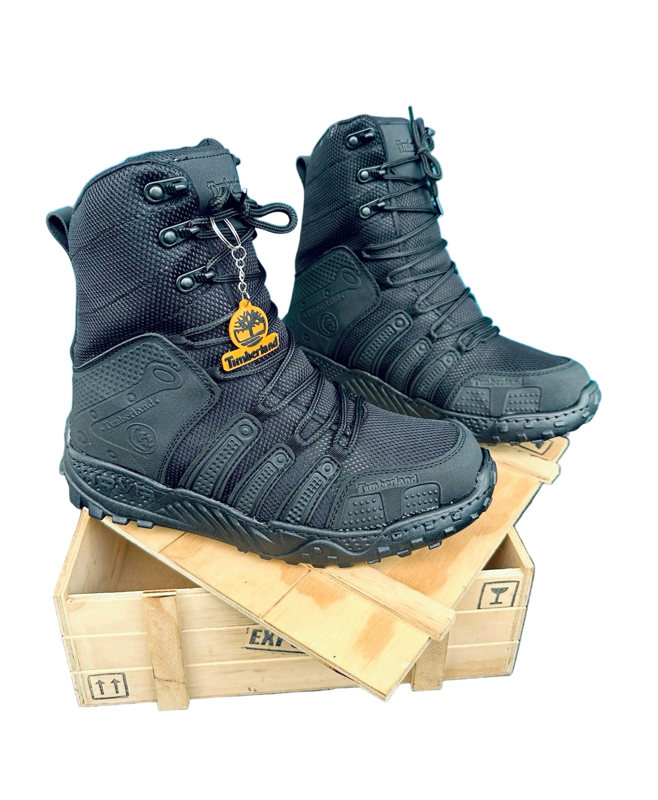 Black tactical boots on a wooden crate with a blue background